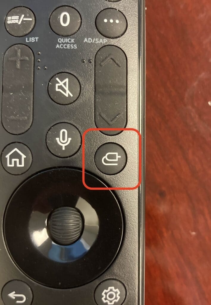 close up of a tv remote with the input icon circled in red