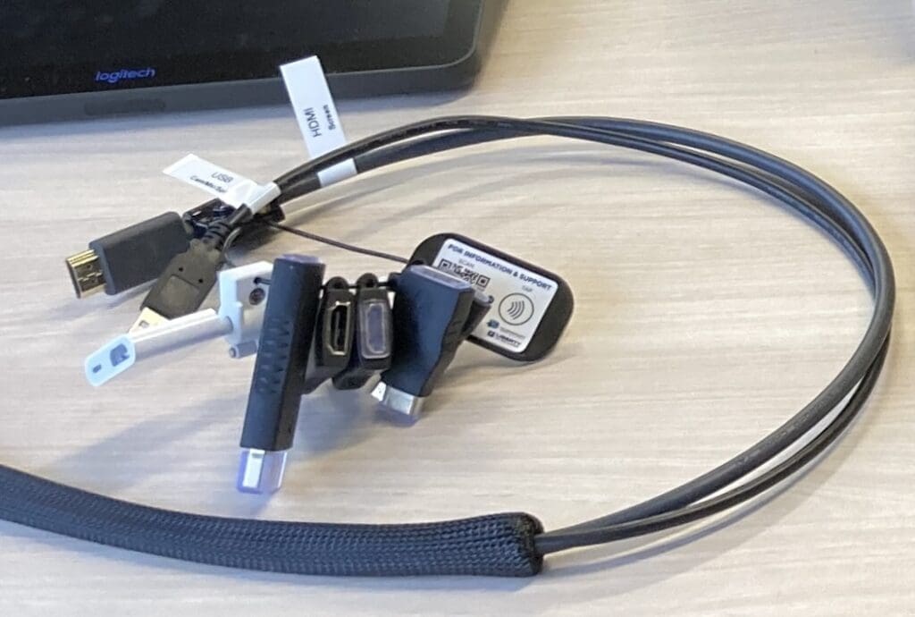 Multiple computer cables, plugs and adapters that have been strung together.