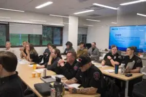 Members of the South County Fire department sit in a School of Social Work research commons classroom for a BHCore-led training session.