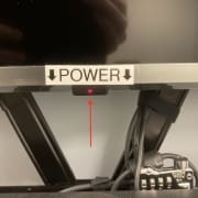 tv monitor with a sticker that reads "power" and arrows pointing to the bottom of the monitor where the power button is located.