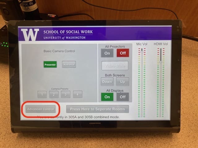 Touchscreen monitor turned on with the university of washington logo at the top and various buttons displayed to control various classroom audio visual needs. The words Advanced Controls are circled in red.