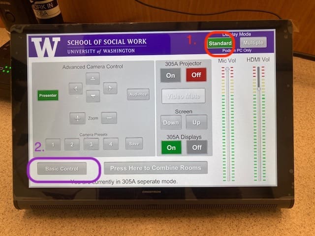 Touchscreen monitor turned on with the university of washington logo at the top and various buttons displayed to control various classroom audio visual needs. The word Basic Control is circled in purple and a green button is circled in red..